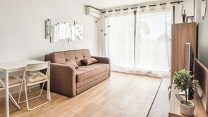 Een moderne woonkamer met een bank, een eettafel en stoelen.