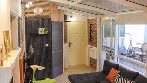 Uma sala de estar moderna com um sofá, uma mesa de centro, um relógio e vista para o exterior.