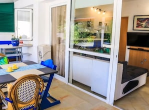 A compact living space with a dining area, a kitchenette, a balcony with a view, and a television. - Deluxe Sea Apartments Markov (Zadar)