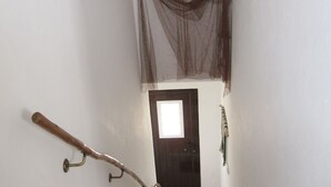 Een kamer met een deur, een haak aan de muur en een hangend voorwerp.