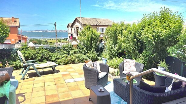 A patio with outdoor furniture, a swimming pool, and a view of the sea. - Apartment Ora al Mare - 32002 (Pedreña)