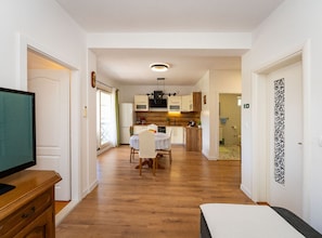 A compact apartment with a dining area, kitchenette, and a TV on a wooden dresser. - Comfort Villa Šolo (Ploce)