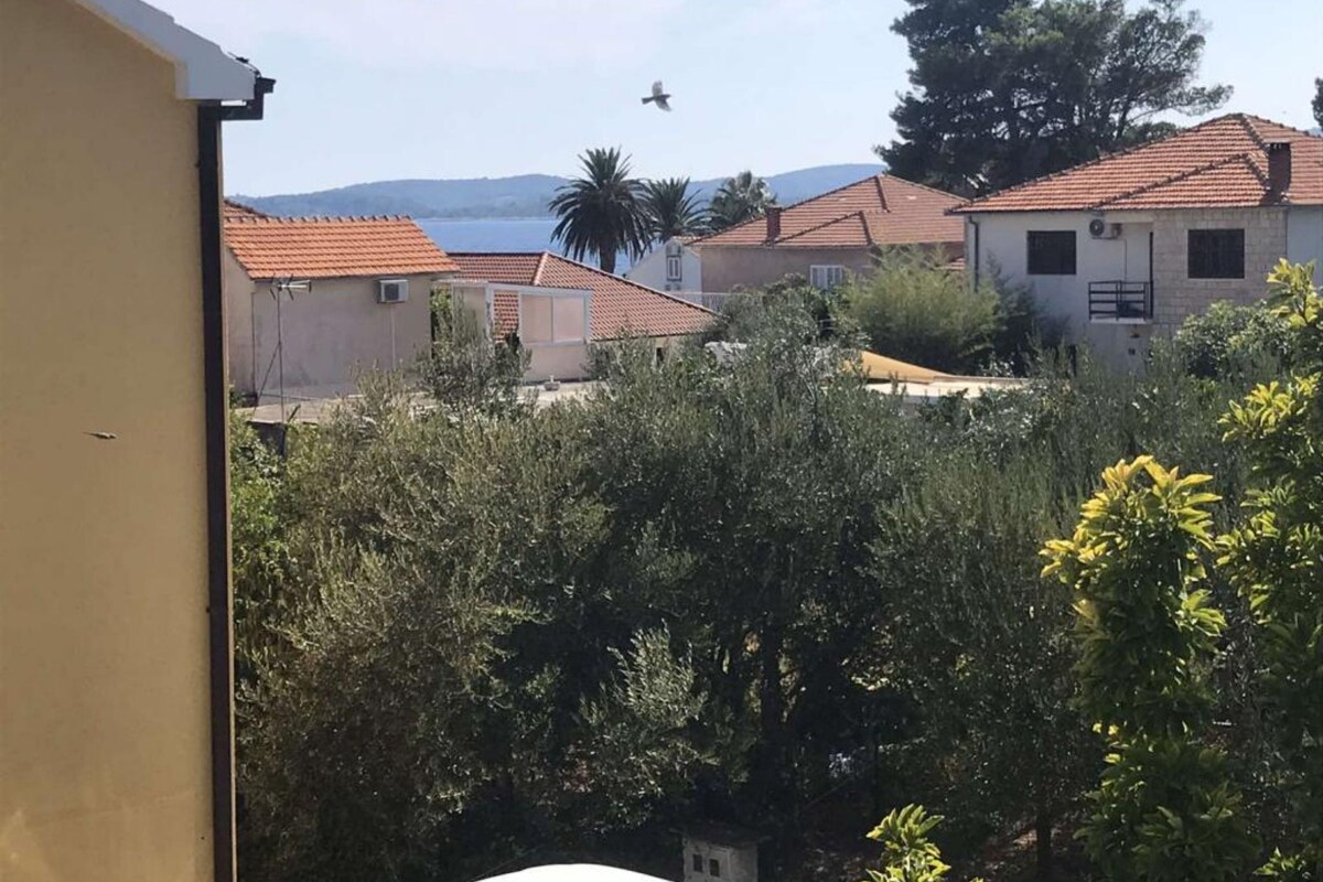 Ein Wohngebiet mit Häusern, blauem Himmel und einem fliegenden Vogel.