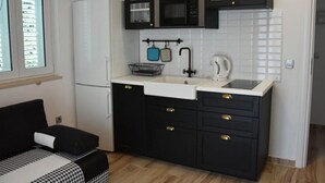 A compact kitchen with a refrigerator, microwave, sink, and cabinets. - Apartments Near the Beach Orebic (Orebic)