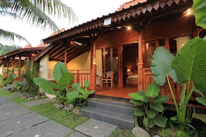 A wooden building with a porch, steps, and large plants. - Laksmi Viridis Villas (Gianyar)