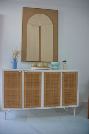 A white cabinet with four doors, each with a woven texture, and a blue vase on top. - Lux 2-Story 3BR Villa + Private Pool (Punta Cana)