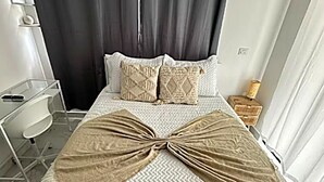 Ein Hotelzimmer mit Bett, Schreibtisch, Stuhl und Nachttisch.