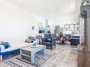A modern living room with a sofa, chairs, a coffee table, and a kitchen area in the background. - Impasse des cabanons by Interhome (Cadolive)