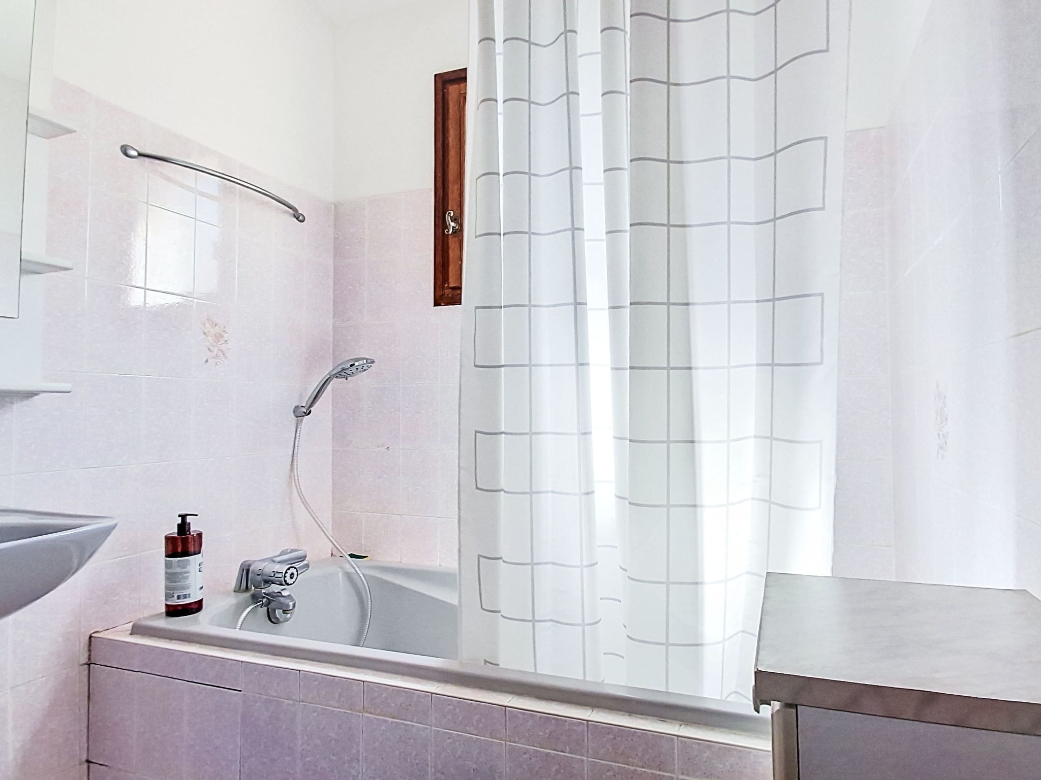 A bathroom with a bathtub, a shower, a sink, and a mirror.