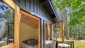A wooden cabin with a bed, a small table, and a deck. - Skärgårdshem by Interhome (Dalarö)