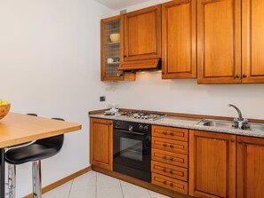Eine Küche mit Holzausstattung, einem Gasherd, einem Backofen und einem Spülbecken.