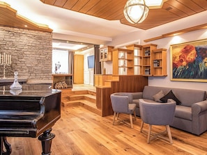 A living room with a grand piano, a sofa, and a fireplace. - Villa 10 by Interhome (Ötz)