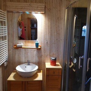 Een douche, handdoeken, zeep, toiletpapier