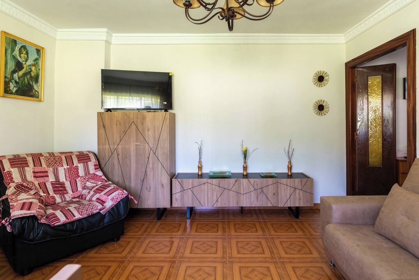 A living room with a sofa, a coffee table, a TV, and a decorative console.
