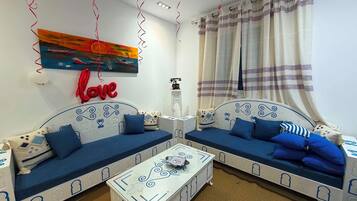 Un salon chaleureux avec deux canapés, une table basse et un tableau accroché au mur.