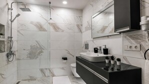A modern bathroom with a glass-enclosed shower, a black vanity with a sink, and a toilet. - Magical 2 Bedroom Apartment At Monnas Suite (Istanbul)