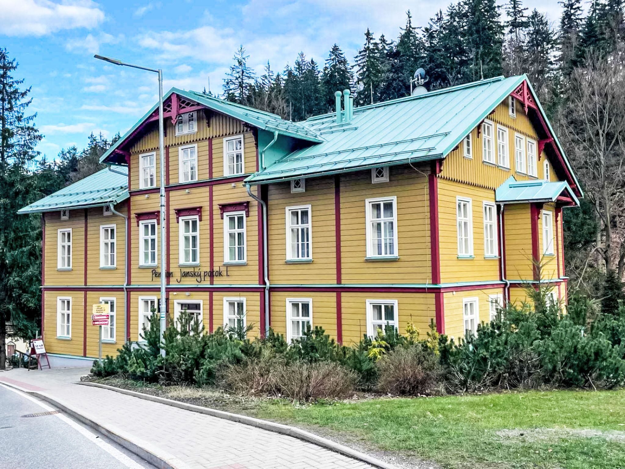 Ein mehrgeschossiges Gebäude mit Gründach, umgeben von Pflanzen und Bäumen.