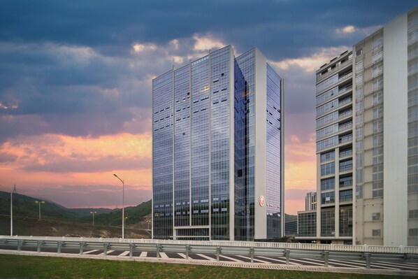 A modern building with a glass facade, a flat roof, and a rectangular shape.