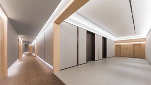 A modern hallway with a carpeted floor, wooden paneling, and a series of doors. - JI Hotel Shenzhen Xiaomeisha (Shenzhen)