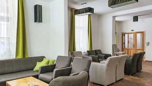 Un espace de détente moderne, avec des canapés, des fauteuils et une table basse en bois.