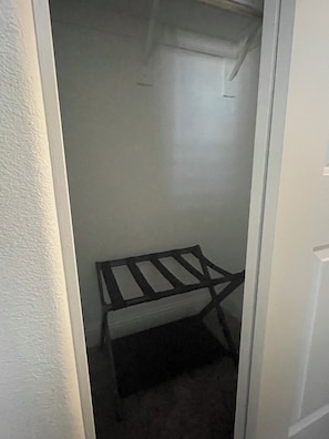 A narrow hallway with a metal shelf unit against the wall.
