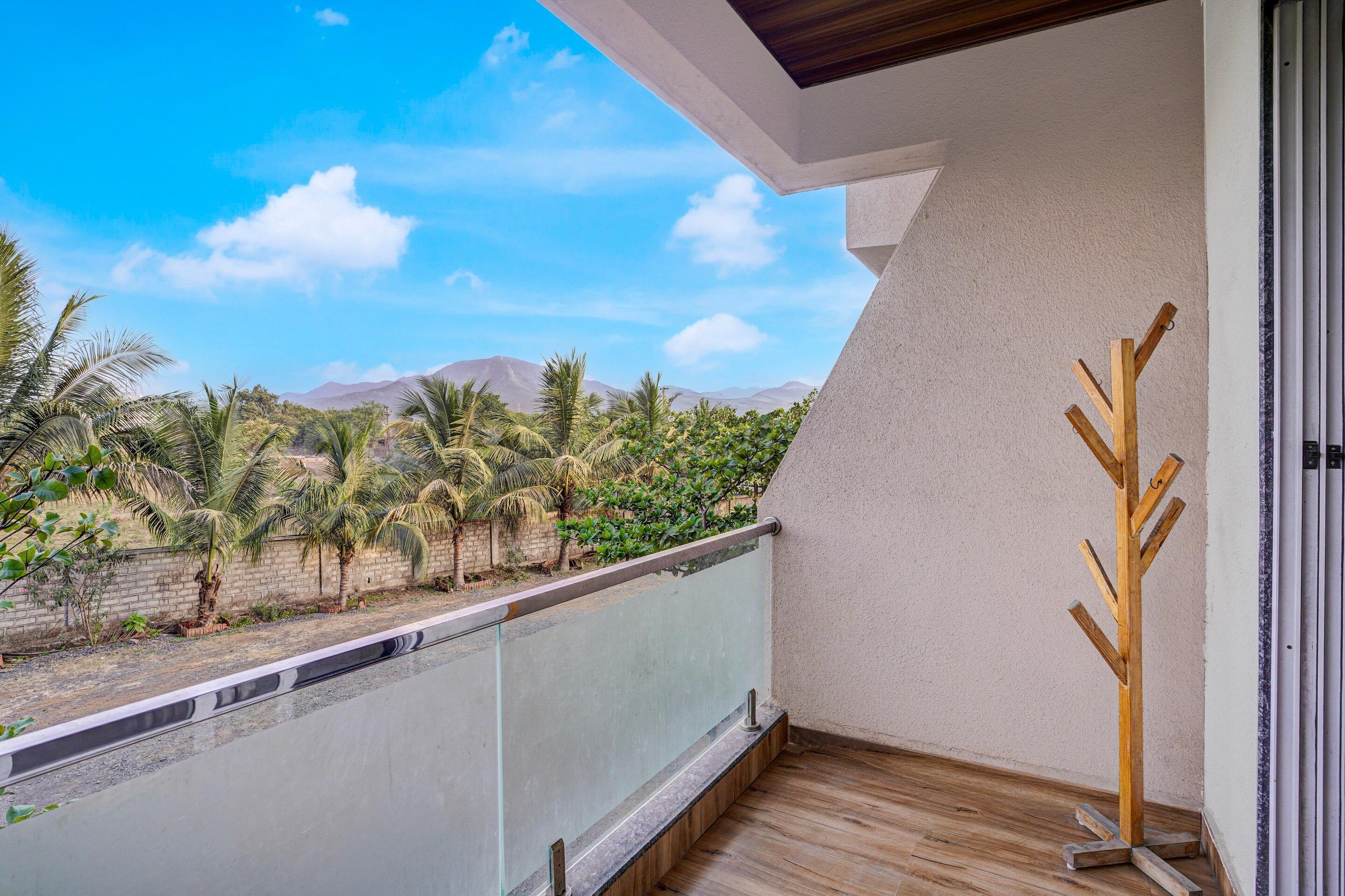 A balcony with a view of palm trees and mountains.