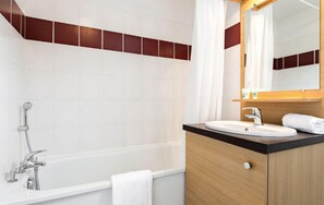 Une salle de bain moderne avec une baignoire, un lavabo et un miroir.