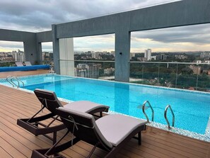 A rooftop infinity pool with lounge chairs and a city view. - NATURE RETREAT WITH RUSTIC CHARM (Nairobi)