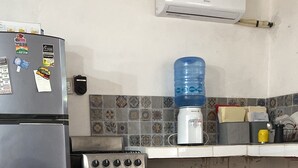 Eine Küche mit Kühlschrank, Herd und Wasserspender.