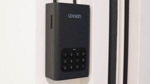 Una serratura elettronica con tastierino nero montata su una porta bianca.