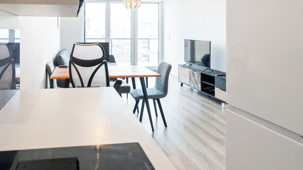 Una cucina moderna con zona pranzo, ampie finestre e televisore a schermo piatto.