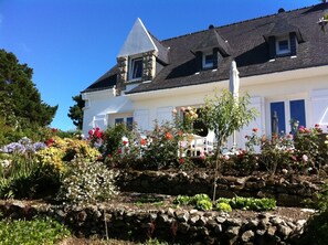 A white building with a stone wall garden, a stone tower, and a sloped roof. - Family home with exceptional view of the Gulf of Morbihan - Sleeps 8 (Arzon)