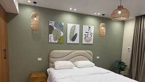 A modern bedroom with a bed, wall art, and pendant lights. - Diarna Downtown Residency (Marsa Matrouh Governorate)