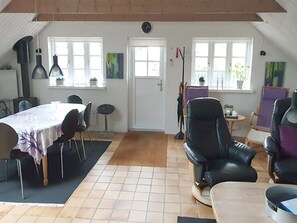 Ein Essbereich mit einem Tisch, Stühlen und einem schwarzen Ledersessel.