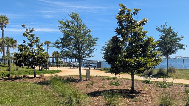 A park with trees, a pathway, and a view of the water. - The Navarre Nook at The Spires - Near Navarre Beach & Pier (Navarre)