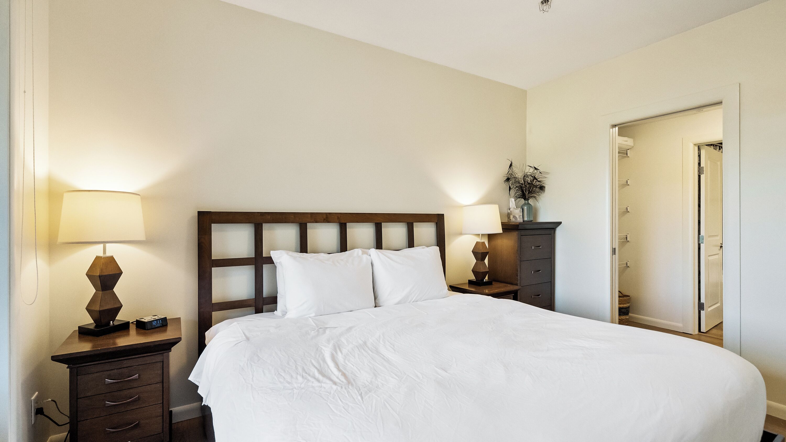 Ein Hotelzimmer mit einem großen Bett, zwei Nachttischen, einer Kommode und einem Spiegel.