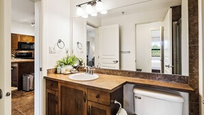 A bathroom with a large mirror, a sink, and a toilet. - Bright 3 Bd at Playa 548. Pool & Beach  (Kelowna)