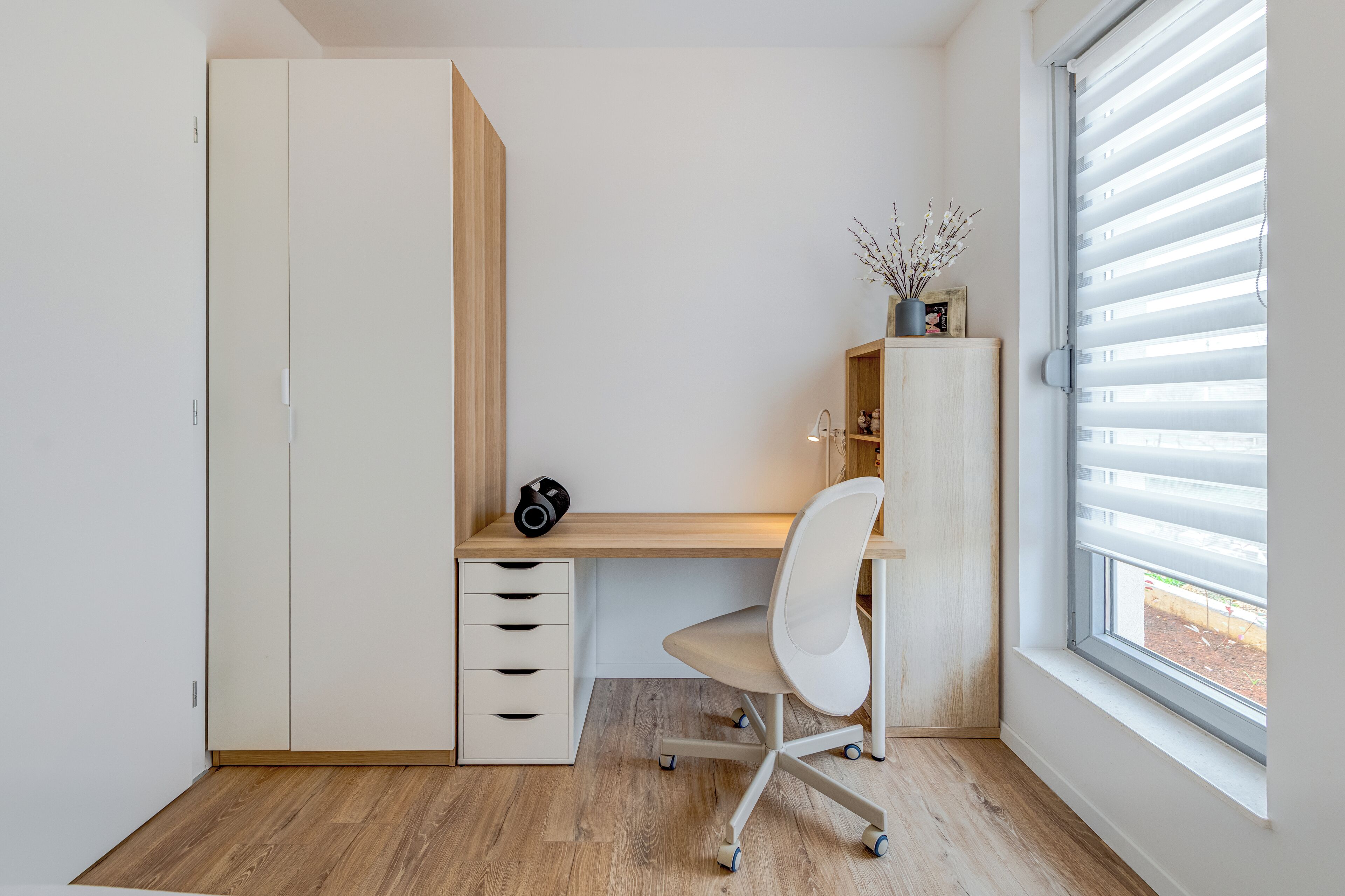 A study room with a desk, chair, and wardrobe.