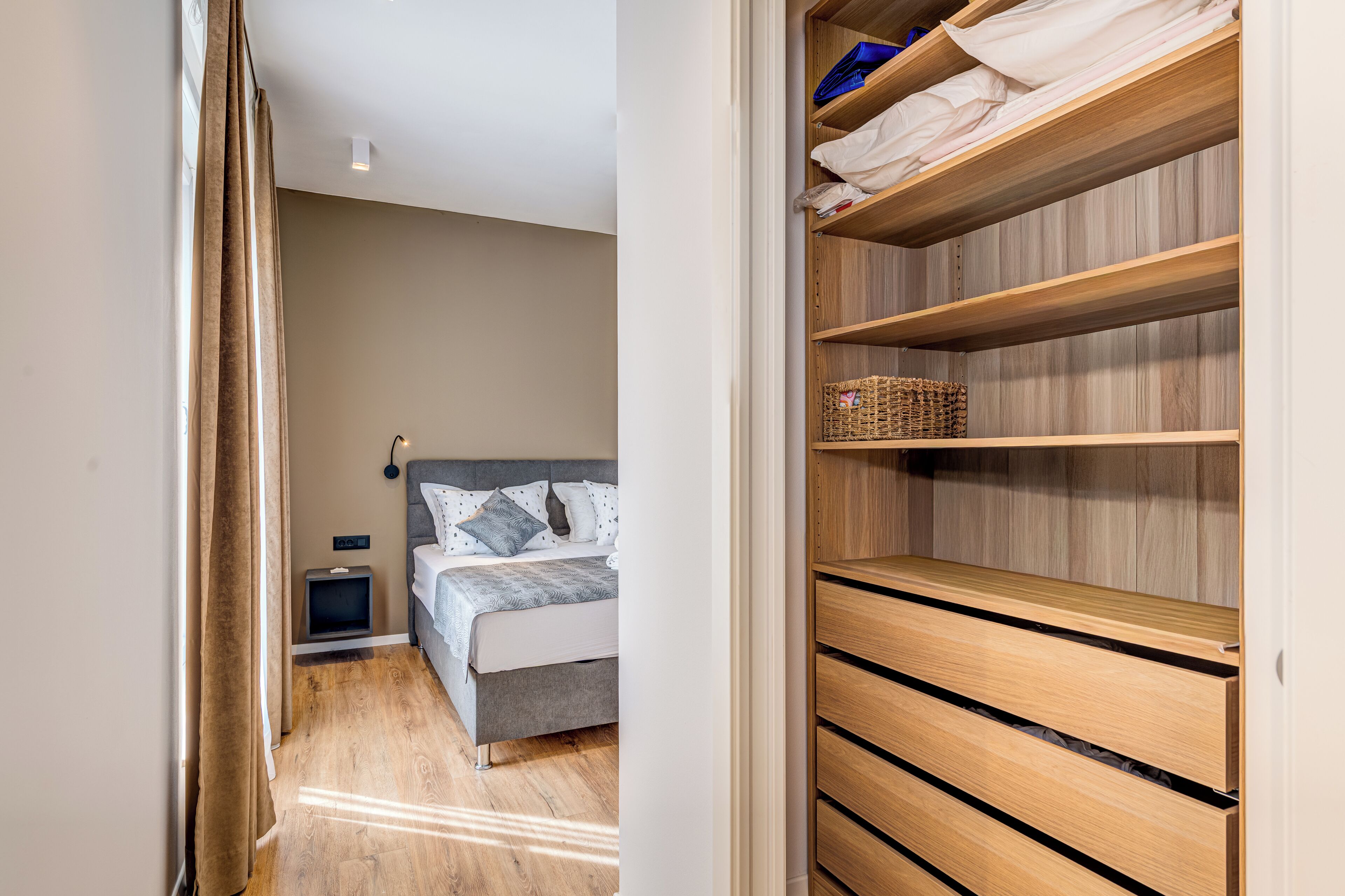Un dormitorio con cama, mesita de noche y un armario de madera.