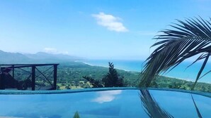 A clear sky, a pool, and a distant view of a landscape.