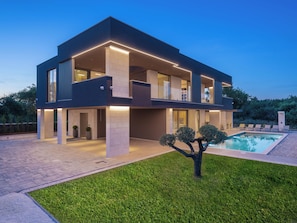 A modern two-story house with a swimming pool, large windows, and a well-maintained lawn. - Vacation home Teulu by Interhome (Pula/Krnica)