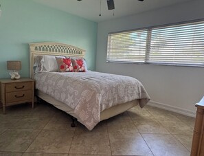 A bedroom with a bed, nightstand, lamp, and window with blinds. - Spacious 3BR/2BA home close to Sanibel/Fort Myers Beaches and SWFL attractions (Fort Myers)