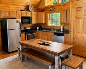 A wooden cabin-style kitchen with a refrigerator, stove, microwave, sink, and wooden cabinets. - 3 bedroom cabin near Dollywood.  Mountain views, hot tub, games, community pool. (Sevierville)