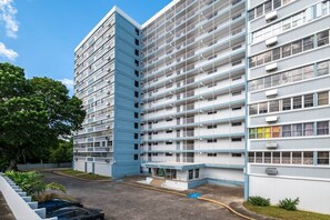 A multi-story hotel with a central courtyard, balconies, and a parking area. - Cozy 3BR Condo Pool  10 minutes to Airport (Carolina)