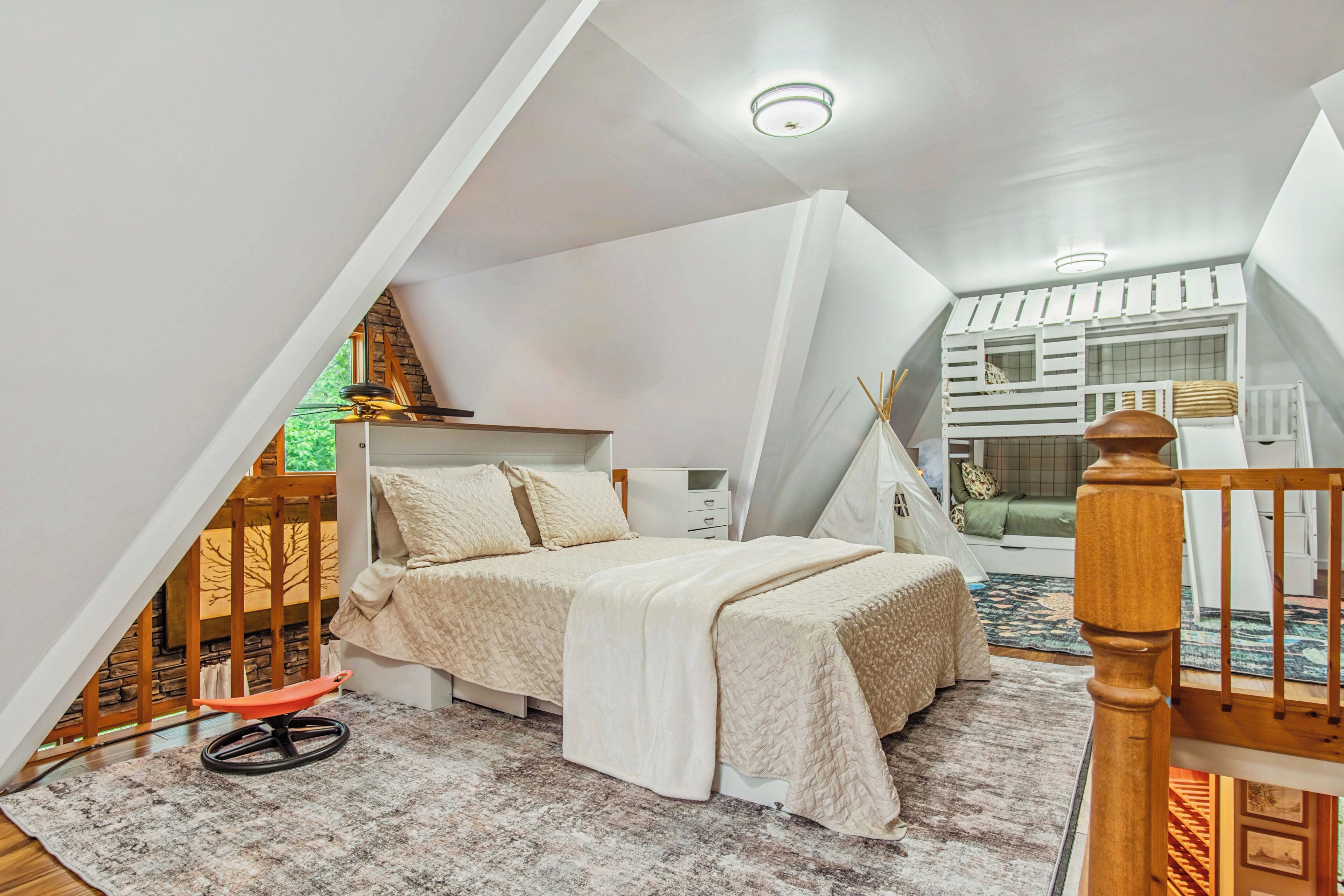 A bedroom with a bed, a chair, a desk, and a window.
