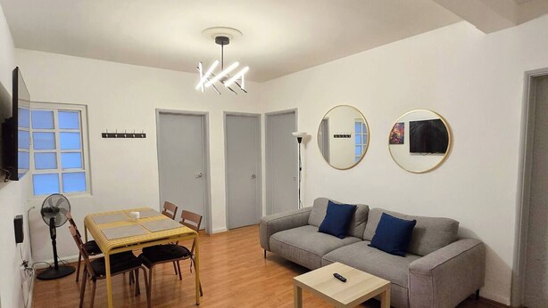 A living room with a dining table, sofa, and a ceiling light fixture. - Apartment in Condesa with a Terrace (Ciudad de México)