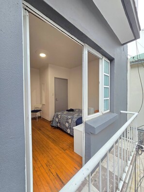 A room with a bed, a chair, a desk, and a window. - Apartment in Condesa with a Terrace (Ciudad de México)