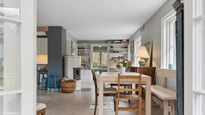 Un rincón comedor acogedor con una mesa y sillas de madera, un cesto y una lámpara.