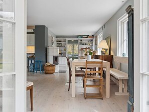Ein gemütlicher Essbereich mit Holztisch und -stühlen, einem Korb und einer Lampe.