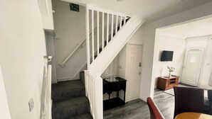 Eine Treppe führt zu einem Essbereich mit Tisch und Stühlen.